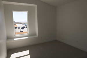 Empty room featuring carpet and baseboards