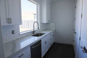 Kitchen featuring dishwasher, a sink, tasteful backsplash, and a wealth of natural light