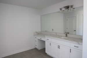 Bathroom featuring baseboards, vanity, and tile patterned floors