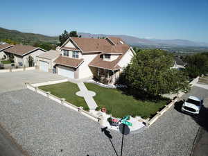 View of front of home featuring concrete driveway, a mountain view, and a residential view