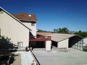 Rear view of property featuring a mountain view, stucco siding, and a carport