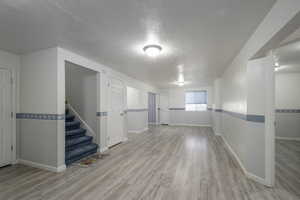 Interior space with baseboards, wood finished floors, and stairway