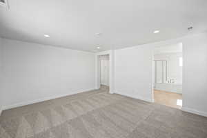 Unfurnished room with baseboards, visible vents, recessed lighting, and carpet