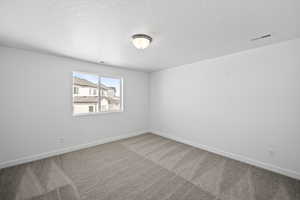 Unfurnished room with baseboards, carpet flooring, and a textured ceiling