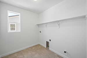 Laundry area with hookup for a gas dryer, washer hookup, baseboards, laundry area, and hookup for an electric dryer