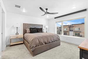 Carpeted bedroom with baseboards, visible vents, and a ceiling fan