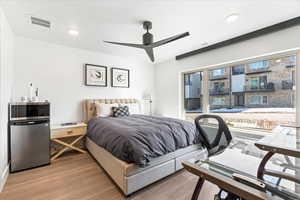 Bedroom with visible vents, recessed lighting, light wood-type flooring, and freestanding refrigerator