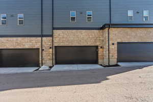 View of property exterior featuring stone siding and an attached garage