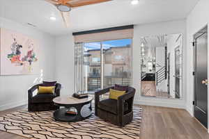 Sitting room featuring baseboards, visible vents, wood finished floors, and recessed lighting