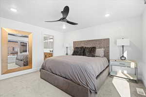Carpeted bedroom featuring baseboards, recessed lighting, ensuite bath, and a ceiling fan