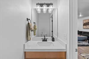 Bathroom with toilet, vanity, and wood finished floors