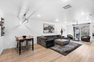 Living area featuring light wood-type flooring, baseboards, and visible vents
