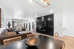 Living room featuring a ceiling fan, baseboards, a fireplace, and light wood-type flooring
