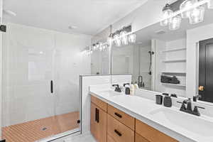 Full bath featuring double vanity, visible vents, a sink, and a stall shower
