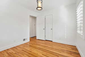 Interior space with baseboards, visible vents, and light wood-style flooring