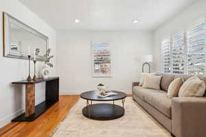 Living area with light wood finished floors, baseboards, and recessed lighting
