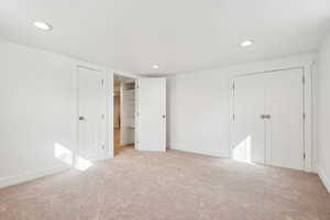Unfurnished bedroom featuring baseboards, a closet, light colored carpet, and recessed lighting