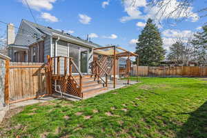 Back of house featuring a fenced backyard, a lawn, and a deck