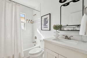 Full bathroom with shower / bath combination with curtain, toilet, and vanity