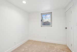 Empty room featuring light colored carpet, recessed lighting, and baseboards