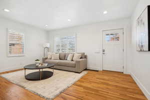 Living room with baseboards, a wealth of natural light, visible vents, and light wood finished floors