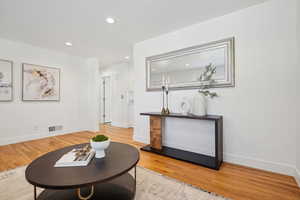 Living area featuring baseboards, recessed lighting, visible vents, and light wood-style floors