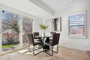 Dining room with light tile patterned flooring, baseboards, and recessed lighting