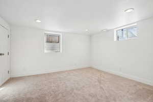 Basement with carpet floors, a textured ceiling, baseboards, visible vents, and recessed lighting