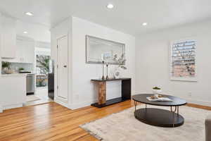 Sitting room with baseboards, light wood-style floors, and recessed lighting