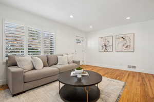 Living room with baseboards, visible vents, recessed lighting, and light wood-type flooring