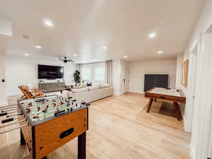 Recreation room with a ceiling fan, light wood-style flooring, baseboards, and recessed lighting