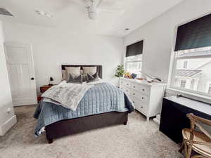 Bedroom with ceiling fan, visible vents, and light carpet