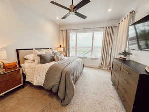 Bedroom with light carpet, ceiling fan, and recessed lighting