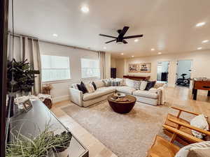 Living area featuring a ceiling fan, recessed lighting, baseboards, and wood finished floors
