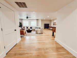 Living room with a ceiling fan, light wood finished floors, baseboards, visible vents, and recessed lighting