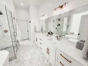 Full bathroom with marble finish floor, a freestanding tub, a sink, and a marble finish shower