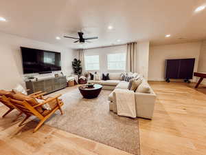Living room featuring light wood-type flooring, recessed lighting, and a ceiling fan