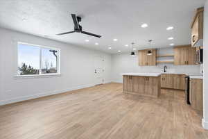 Kitchen featuring light countertops, open shelves, stainless steel microwave, electric range, and ceiling fan