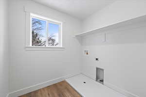 Clothes washing area with washer hookup, wood finished floors, hookup for an electric dryer, laundry area, and baseboards