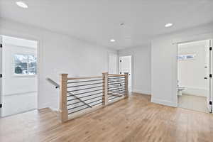Spare room featuring baseboards, light wood-style flooring, and recessed lighting