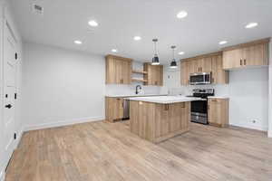 Kitchen featuring light countertops, backsplash, open shelves, light wood-type flooring, and stainless steel appliances