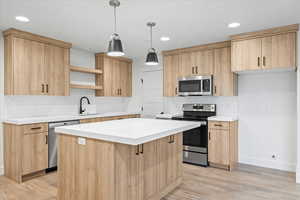 Kitchen with a sink, light brown cabinetry, and appliances with stainless steel finishes