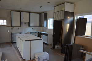 Kitchen with fantastic amount of storage in custom cabinetry, oversized island dining area,  island, tall ceiling and oversized windows