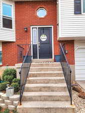 Property entrance with brick siding and a garage