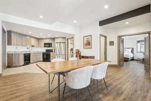 Dining room with recessed lighting, beam ceiling, baseboards, and light wood-type flooring