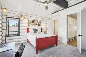 Carpeted bedroom with lofted ceiling with beams, baseboards, and ceiling fan