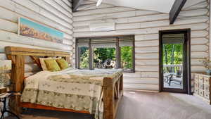 Bedroom featuring log walls, a wall unit AC, carpet flooring, access to outside, and multiple windows