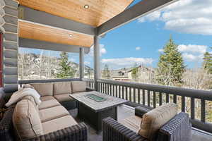 Wooden terrace featuring an outdoor living space with a fire pit