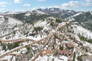 Snowy aerial view featuring a mountain view and a residential view