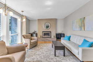 Living room with a textured ceiling, a fireplace, and wood finished floors